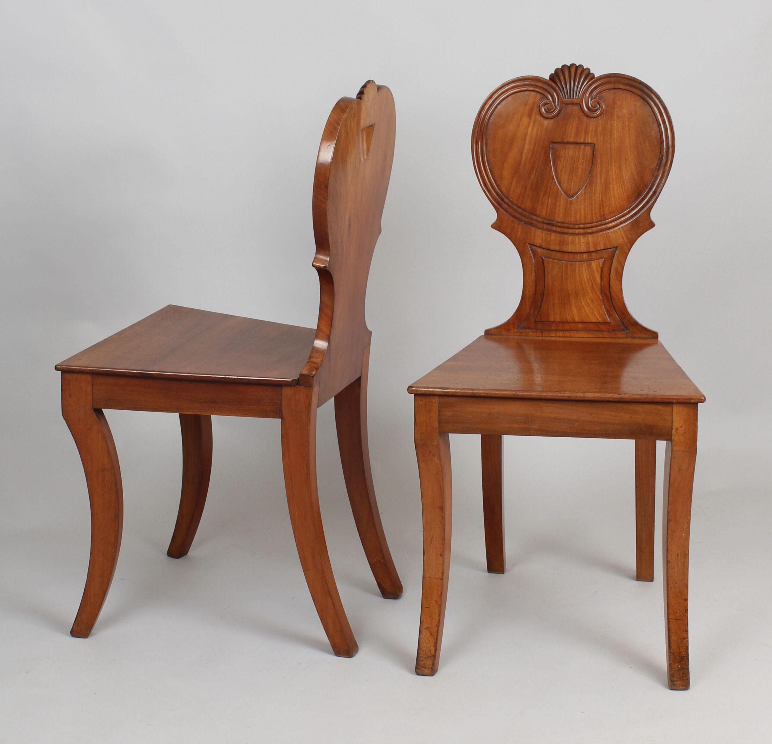 Pair of Regency period pale mahogany hall-chairs