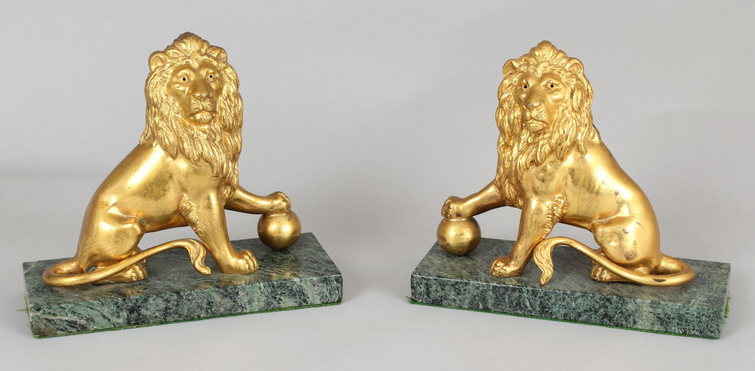 Pair of mid 19th century cast and chased ormolu figures of lions sejant