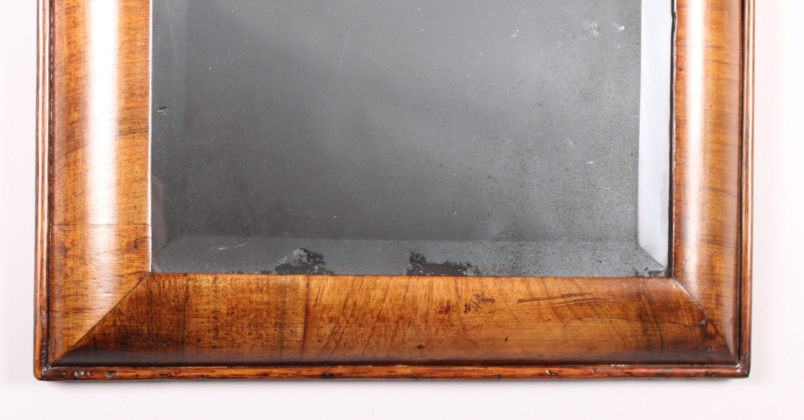Early 18th century walnut cushion-frame mirror