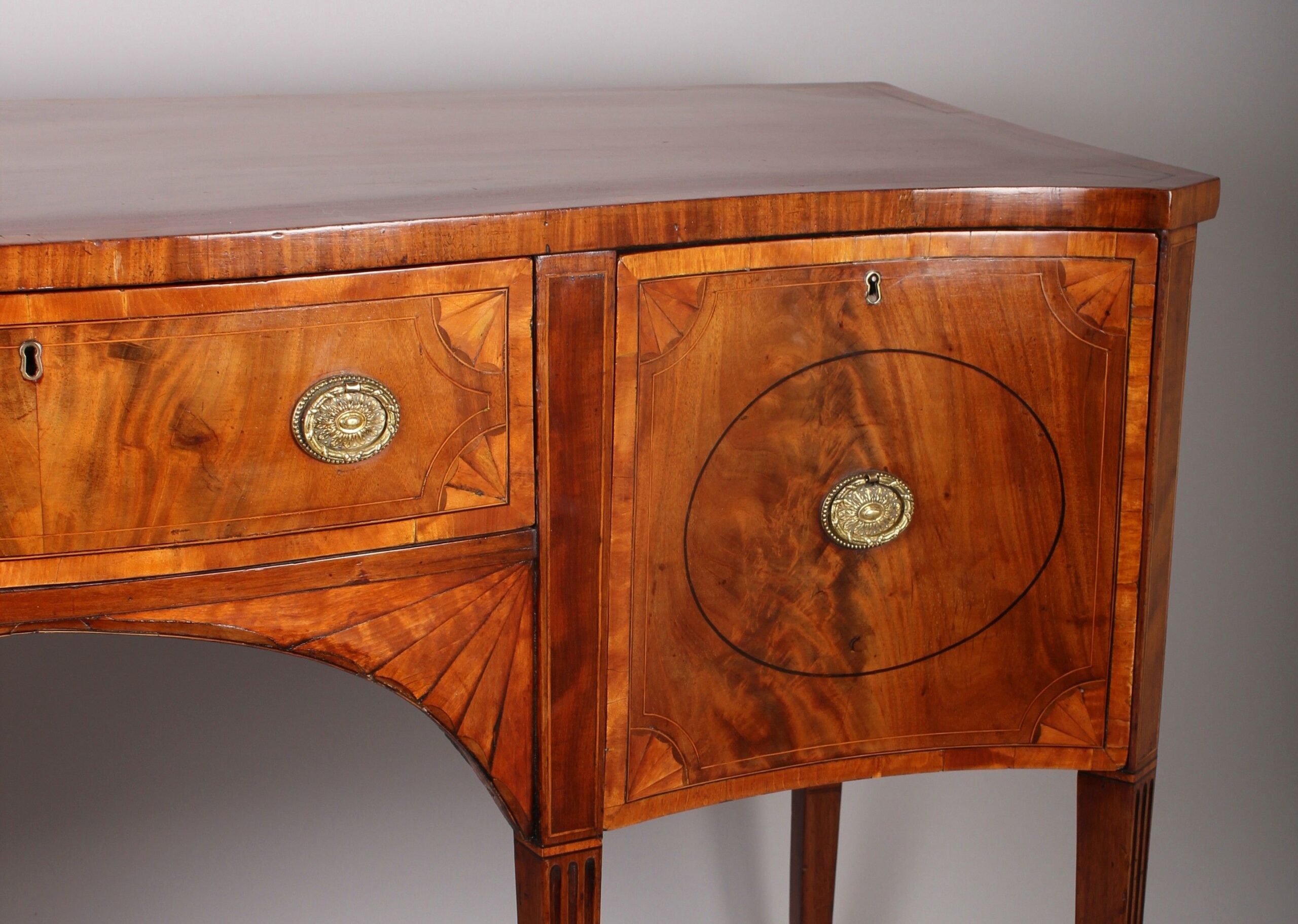 George III period mahogany and satinwood banded serpentine-fronted sideboard