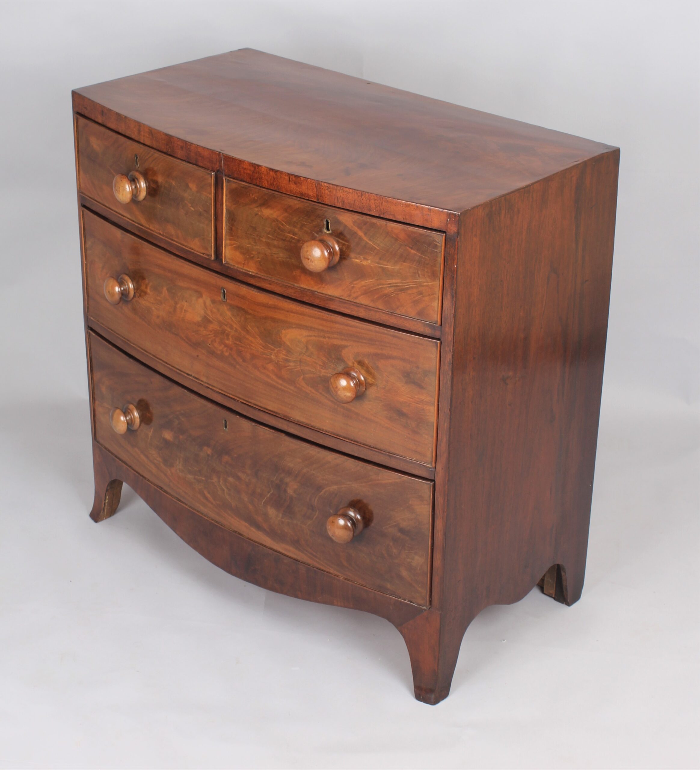 A small early Victorian bow-fronted mahogany chest of drawers