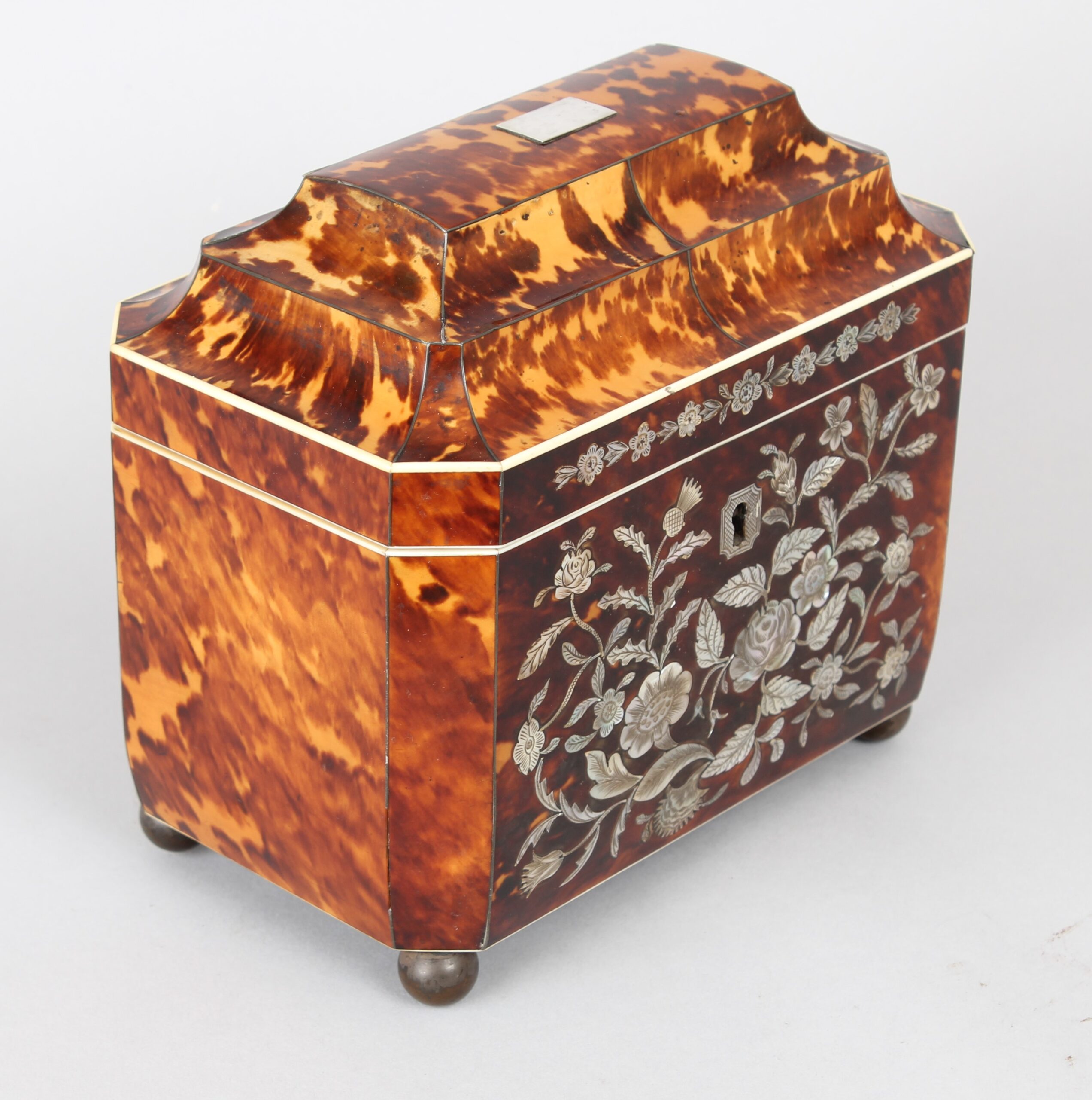 A fine WIV period casket shaped well figured tortoiseshell and engraved mother of pearl inlaid tea caddy