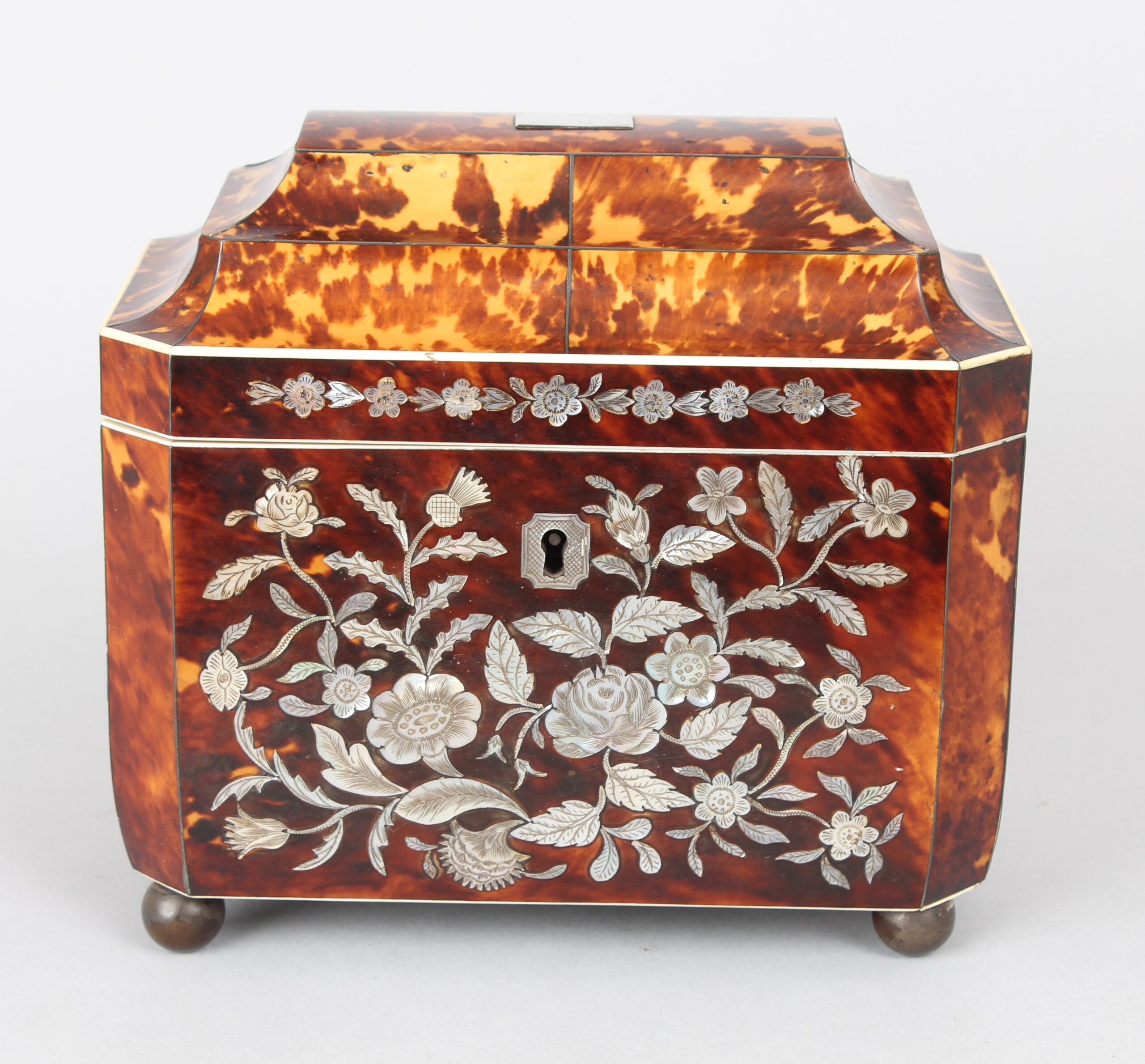 A fine WIV period casket shaped well figured tortoiseshell and engraved mother of pearl inlaid tea caddy