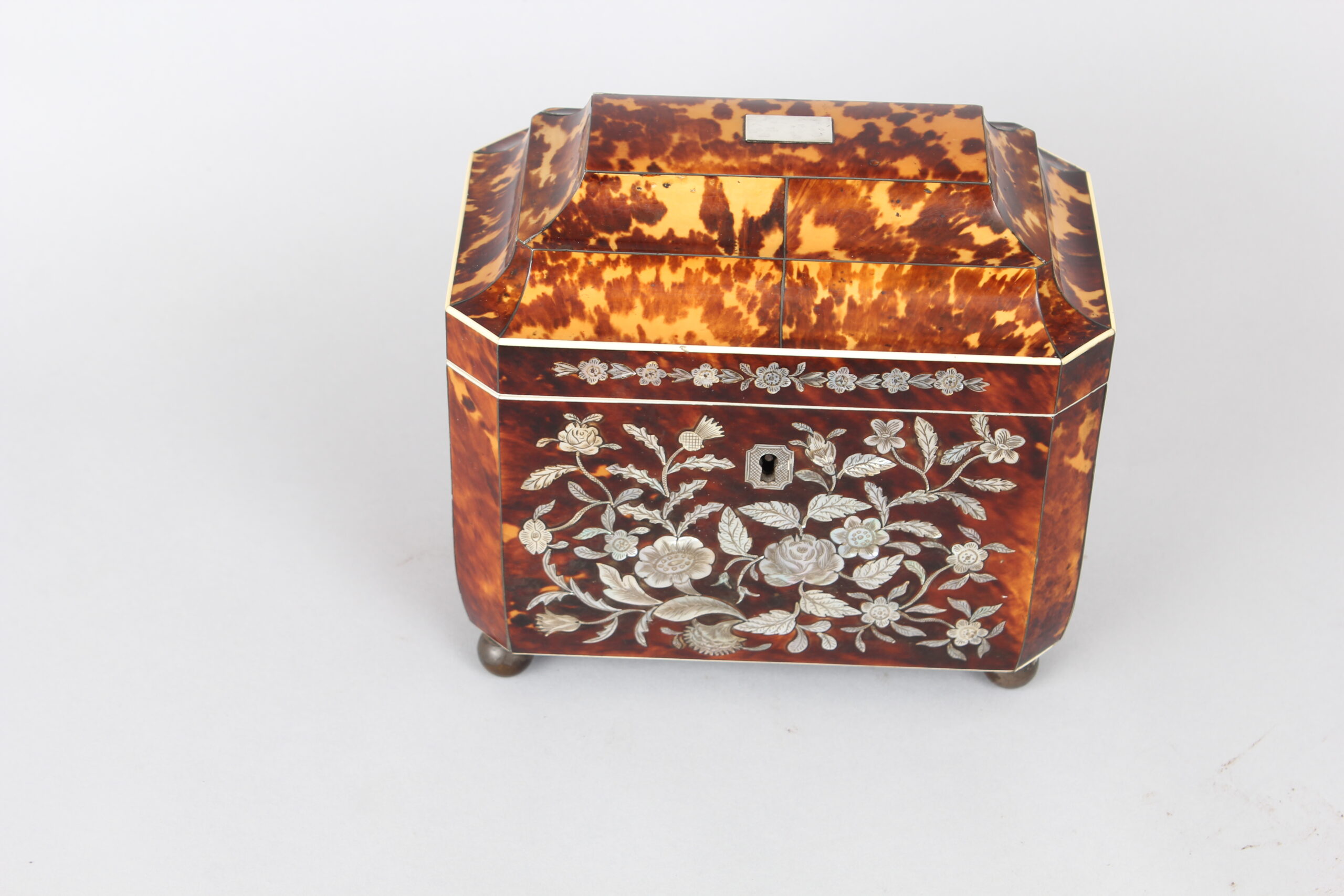 A fine WIV period casket shaped well figured tortoiseshell and engraved mother of pearl inlaid tea caddy