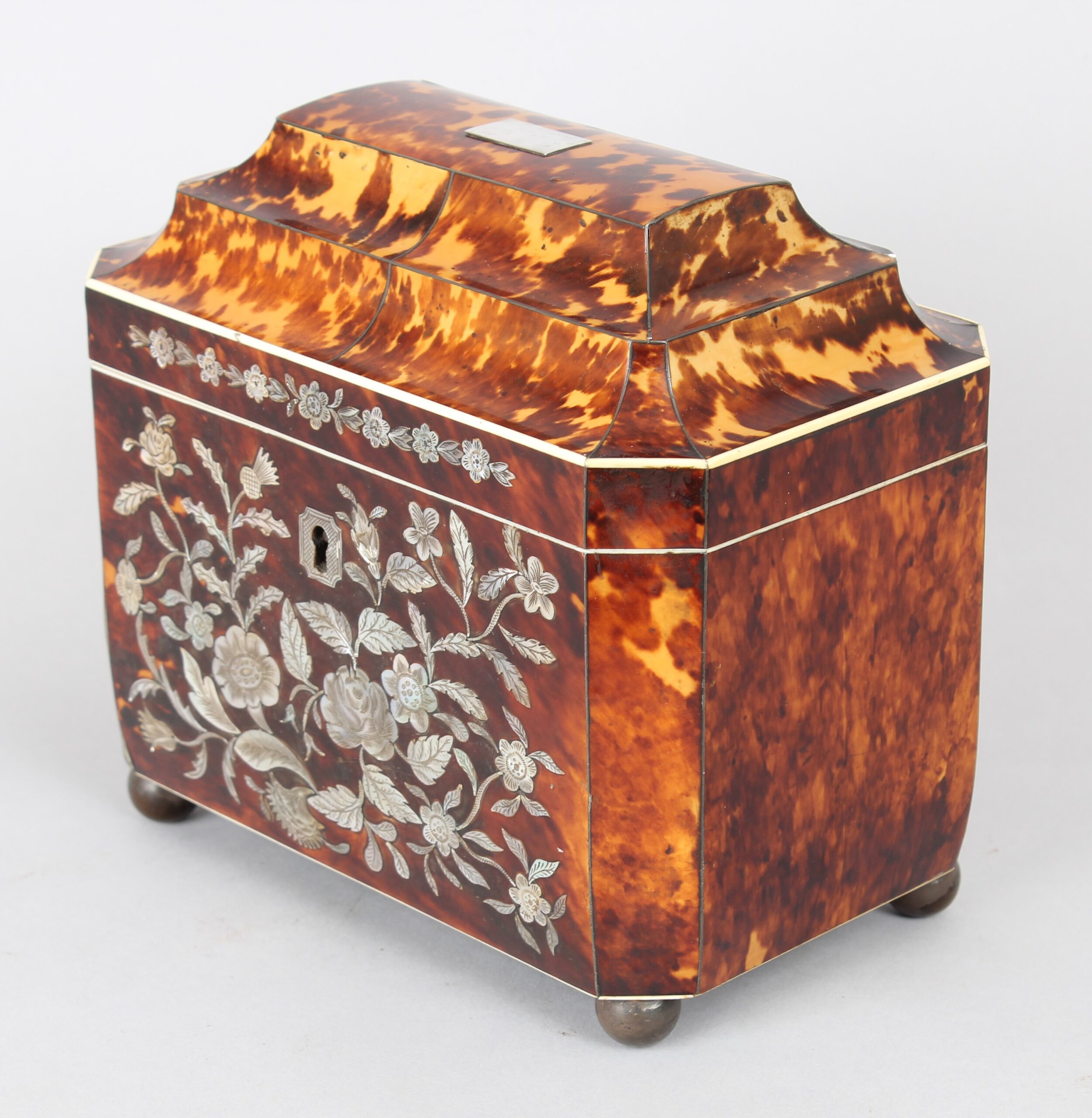 A fine WIV period casket shaped well figured tortoiseshell and engraved mother of pearl inlaid tea caddy