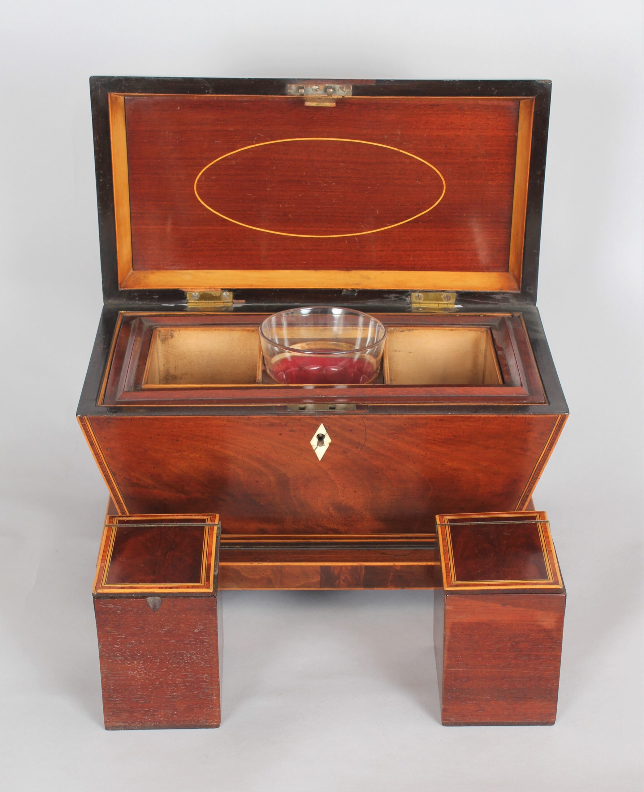 A bold mahogany sarcophagus shaped tea caddy